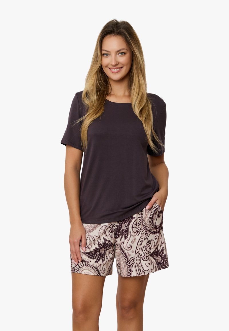 Ciemnofioletowa koszula z krótkim rękawem w połączeniu z jasnobeżowymi szortami, z misternym bordowym wzorem liści i zawijasów.