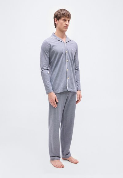Γκρι σετ πιτζάμες από απαλό ύφασμα· διαθέτει μακριά μανίκια, πουκάμισο με κουμπιά και τσέπη, και φαρδιά παντελόνια.