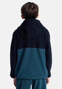 Fleece hoodie in donker marineblauw en teal, met een capuchon en een kleurblokontwerp. Zachte textuur met elastische manchetten en zoom.