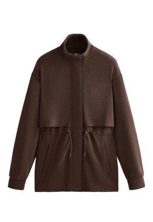 Hnedá skrátená bunda s kapucňou, vysokým golierom, sťahovacou šnúrkou v páse a bočnými vreckami. Mäkká látka a voľný strih.