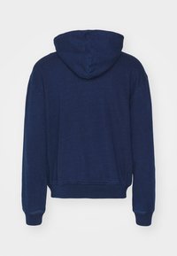 Navyblauer Hoodie mit einer Kordelzugkapuze, gerippten Bündchen und Saum. Hergestellt aus weichem Material mit einer leicht strukturierten Oberfläche.