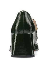 Scarpa in pelle verniciata verde con punta arrotondata e tacco robusto e lucido. La vista posteriore mostra una superficie liscia e accenti di design minimali.