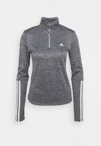 Szara bluzka z długim rękawem z zamkiem błyskawicznym do ćwierć długości, wykonana z teksturowanej tkaniny. Posiada białe akcenty w postaci trzech pasków na rękawach oraz małe logo na piersi.