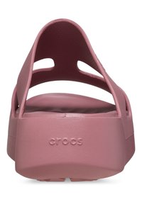 Růžové Crocs s hladkým povrchem, otevřeným zadním dílem a výřezovým designem. Obsahují logo na patě a polstrovanou stélku pro pohodlí.