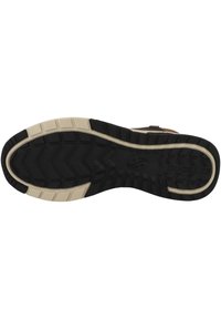 Suela de zapato de goma negra con patrón de textura en la suela, presenta acentos blancos a lo largo del perímetro y marca impresa en la superficie.