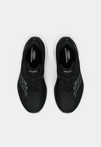 Une paire de chaussures de course noires Saucony avec des semelles intermédiaires blanches, des dessus en mesh et des lacets, vues de dessus sur un fond blanc uni.