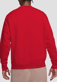 Red sweatshirt made of soft material with a crew neck, long sleeves, and ribbed cuffs and hem, showcasing a simple and classic design.