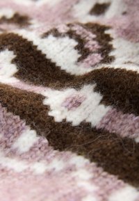Gebreide wollen stof in bruin, roze en wit met een geometrisch patroon, een zachte textuur en zichtbare vezels.