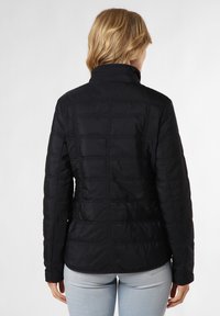 Schwarze Pufferjacke mit hohem Kragen, gestepptem Textur und horizontalen Nähten auf dem Rücken. Weiches, leichtes Material.