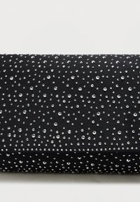 Μαύρη τσάντα χιαστί από ύφασμα, με μοτίβο από μικρές, λαμπερές ραβδωτές πέτρες σε διάφορα μεγέθη, ομοιόμορφα κατανεμημένες στην επιφάνεια.