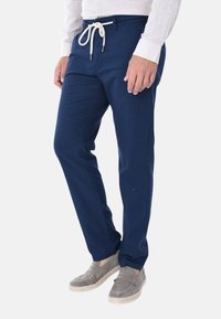 Pantaloni blu navy realizzati in tessuto leggero, con una vita regolabile con cordino, gambe affusolate e sottili pieghe frontali.