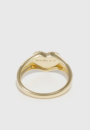 Anillo de oro con un diseño suave y redondeado, con una banda dividida, grabado con "Yvonne Léon 375" en la superficie interior.