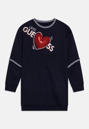 Sudadera azul marino de manga larga con cuello y mangas a rayas, con un corazón rojo de lentejuelas y el texto "LOVE GUESS" en la parte delantera.