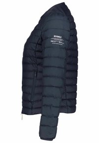 Marinblå puffjacka med ett kviltat mönster, dragkedjefickor och textdetaljer på ärmen. Tillverkad av återvunna material för isolering.