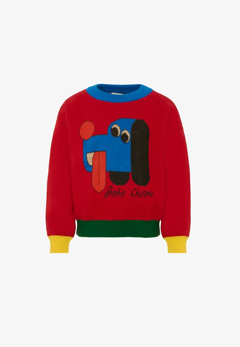 Roter gestrickter Pullover mit einem blauen Hundemotiv, der ihm die Zunge herausstreckt. Akzente in Blau, Grün und Gelb am Kragen und an den Ärmelabschlüssen.