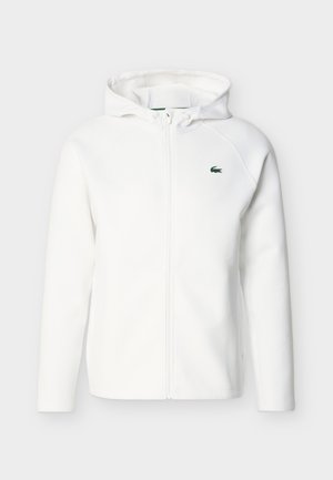 Weißer Kapuzenpullover mit Reißverschluss, langen Ärmeln, Fronttaschen, verstellbarem Kordelzug an der Kapuze und kleinem grünen Krokodil-Logo auf der linken Brust.