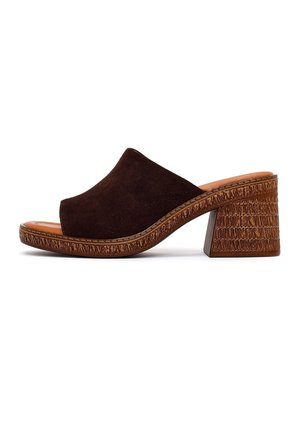 Zueco marrón de ante con puntera abierta, tacón bloque de madera texturizada y suela resistente, vista lateral sobre fondo blanco.
