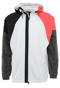 Veste coupe-vent légère ; présente des blocs de couleurs noir, blanc et corail, une capuche, des manches longues, des poignets élastiques et une fermeture éclair frontale.