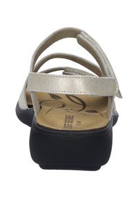 Sandały na paski z metalicznej srebrnej cholewki, regulowanym paskiem na pięcie, czarną podeszwą i wyprofilowaną wkładką z nadrukiem w kwiaty.