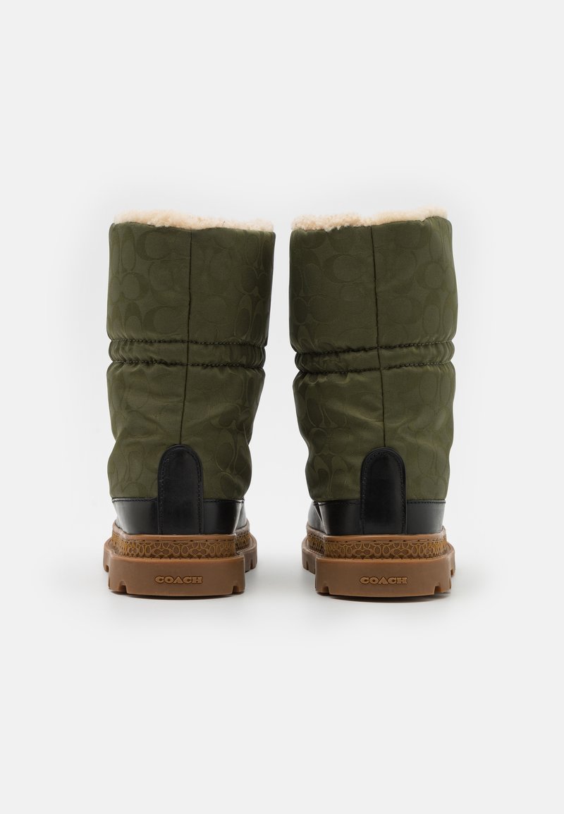 Zielone pikowane buty z teksturowanym czarnym akcentem, brązową gumową podeszwą i miękką beżową podszewką. Posiadają subtelny wzór logo.