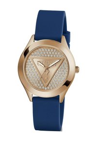 Reloj redondo de tono dorado con una correa de goma azul. La esfera presenta un diseño triangular, rodeado de rhinestones, y tiene agujas del reloj delgadas.