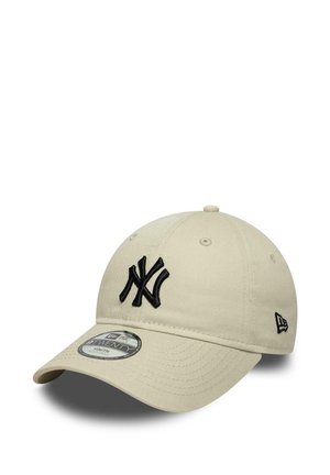 Beige baseball cap with black embroidered "NY" logo on front and adjustable strap, labeled "9TWENTY Youth" on brim sticker.