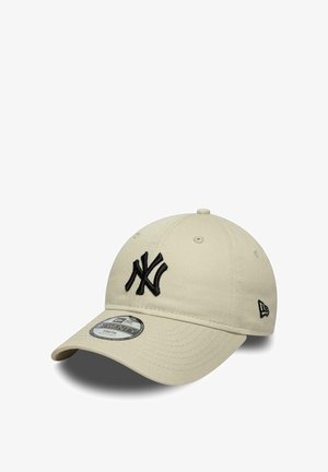 Cappellino da baseball beige con logo "NY" nero ricamato sul davanti e cinturino regolabile, etichettato "9TWENTY Youth" sull'adesivo della visiera.