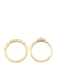 Guld ringe, en med små strukturerede detaljer og den anden med en fremtrædende stenindstilling. Begge har glatte, polerede overflader.