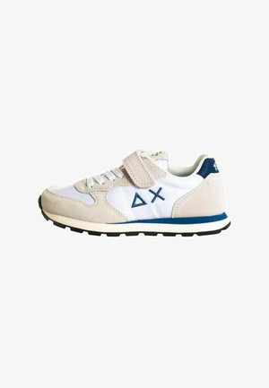 Sneaker bianca e beige realizzata con materiali in suede e pelle, dotata di una fascia in velcro, dettagli blu e suola in gomma nera texture.