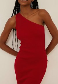 Robe en tricot côtelé rouge avec un design asymétrique à une épaule. Silhouette ajustée, texture lisse et ourlet mi-long. Pas de détails supplémentaires.