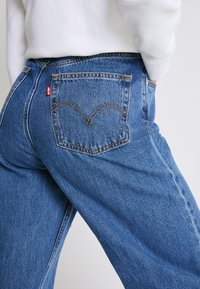 Levi's® HIGH LOOSE - Calças de ganga à boca de sino - blue denim