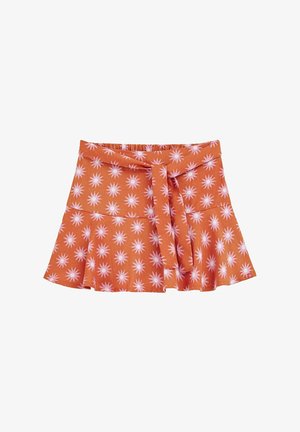 Krátká oranžová sukně s bílým a růžovým vzorem hvězdného výbuchu, s vázačkou v pase a rozšířeným lemem. Vyrobeno z lehkého materiálu s jemnou texturou.