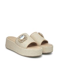 Sandali platform beige intrecciati con punta aperta, decorati con una grande pietra di strass e piccoli cristalli, con una suola intermedia texturizzata per una presa migliore.