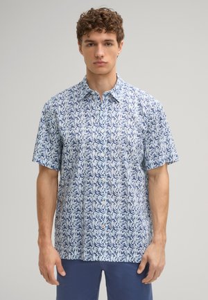 Chemise à manches courtes de couleur bleu clair, ornée d'un motif floral en bleu foncé. Design avec col et fermeture à boutons, fabriquée en tissu léger.