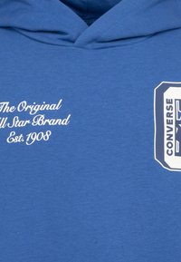 Felpa blu in cotone con cappuccio regolabile. Presenta testo bianco che recita "The Original All Star Brand Est. 1908" e un logo sul lato.