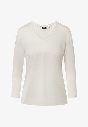 Biała bluzka z długim rękawem i dekoltem w serek o lekko luźnym kroju oraz małą czarną metką marki na tylnej części dekoltu.