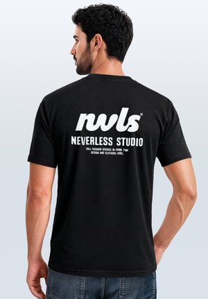 Man wearing a black t-shirt with white text "nwls" and "NEVERLESS STUDIO" on the back, standing against a plain light background.
