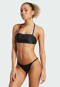 Čierny bandeau bikiny s tenkými ramienkami a textúrovanou tkaninou. Má minimalistický dizajn a detail loga na vrchu. Spodná časť má bočné akcenty.