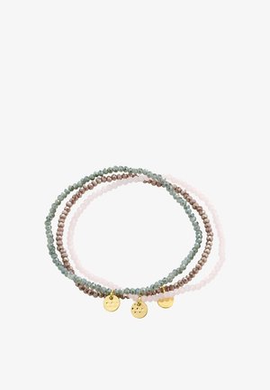 Trois bracelets extensibles avec de petites perles facettées en vert, marron et rose clair, chacun doté d'un petit pendentif rond en or.