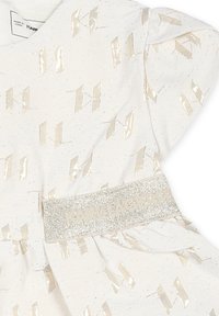 Abito bianco con un motivo lucido e testurizzato caratterizzato da motivi a forma di 'H'. Una cintura scintillante mostra "KARL LAGERFELD" in lettere maiuscole.