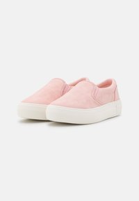 Sapatos cor-de-rosa de deslizar, com uma textura de camurça, apresentando painéis laterais elásticos e uma sola espessa em borracha branca. Design simples e arredondado.