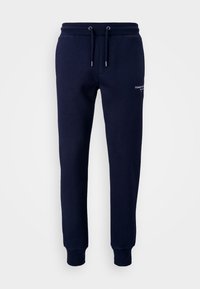 Marina blå sweatpants tillverkade av en blandning av bomull, med resårmidja och dragsko samt ribbade muddarna. Diskret logotypdetalj på benet.