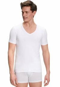 White cotton V-neck t-shirt with short sleeves, smooth texture, fitted design. Worn over white boxer briefs, showcasing simple style.