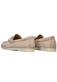 Beige suède instappers met een slip-on ontwerp, voorzien van een gestructureerde bovenkant, vlakke constructie en een lichtgekleurde rubberen zool.