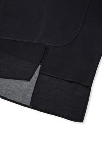 Schwarzes Oberteil mit einem geschichteten Design, das einen glatten äußeren Stoff und eine durchsichtige untere Schicht aufweist, mit gestickten Kanten und geschwungenen Saumlinien.