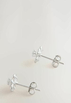 Srebrne kolczyki w kształcie kwiatów z przezroczystymi kryształowymi akcentami, charakteryzujące się gładkim metalicznym wykończeniem i tradycyjnym zapięciem na sztyft.