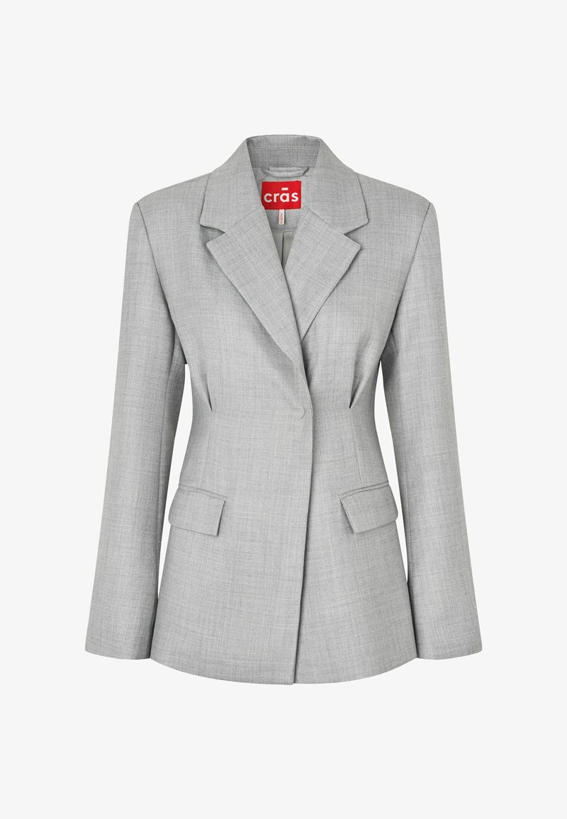 Svetlosivé sako na mieru s výstrihom do písmena V, dvoma prednými vreckami s klapkami a zapínaním na jeden gombík, s nápisom "crās" na vnútornej strane goliera.