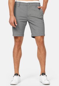 Gray shorts made of a textured fabric, featuring a button closure, front pockets, and rolled hem; paired with white sneaker shoes.