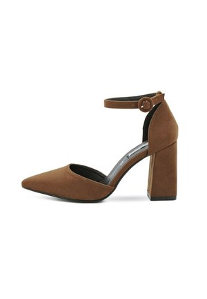 Décolleté in suede marrone con punta affusolata, cinturino alla caviglia con chiusura a bottone e tacco largo per stabilità.