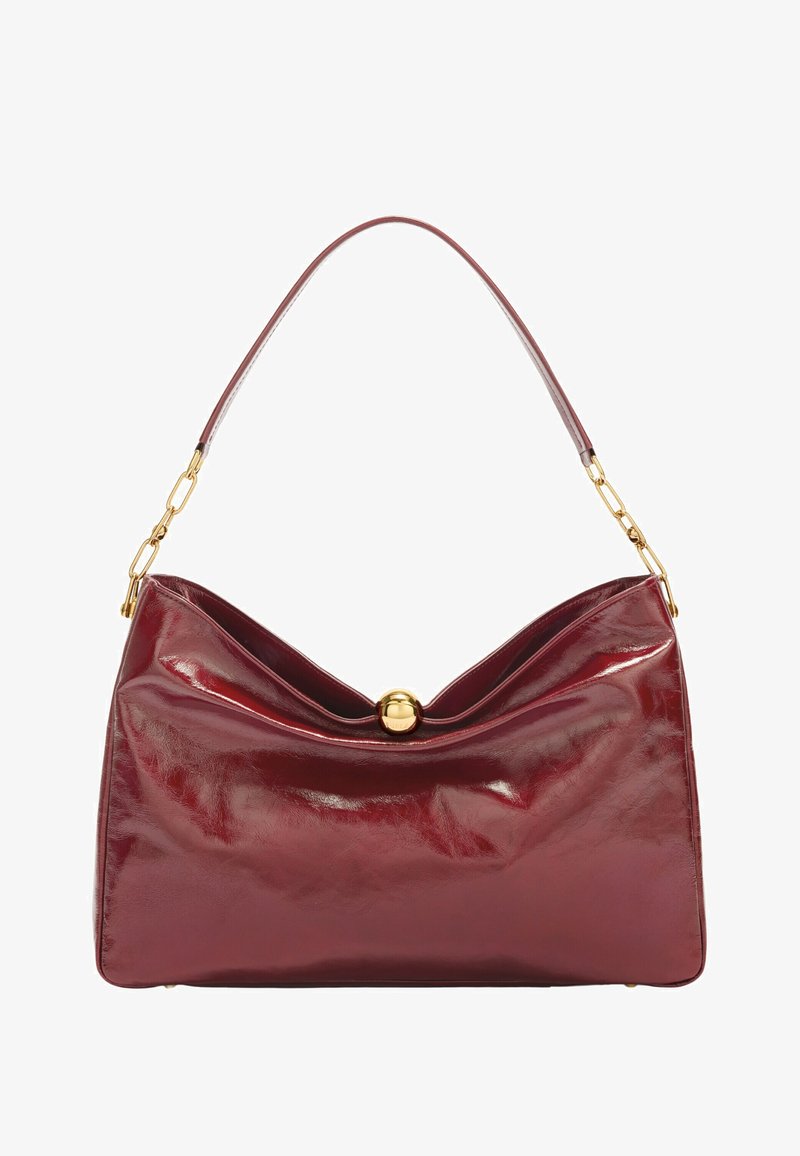 Bolso de cuero rojo con un acabado brillante, que presenta un diseño plegado, un broche circular dorado y una sola correa acentuada con cadena.